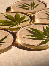 Load image into Gallery viewer, Close-up of a round resin coaster displaying a dried hemp leaf with sharp, detailed edges, creating a bold yet minimalist look.