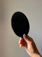 Load image into Gallery viewer, 
Back view of an oval black resin coaster with a smooth, glossy, and opaque surface, showcasing its sleek design
